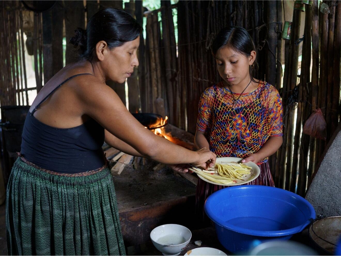 Zusammen mit ihrer Mutter bereitet Norma das Mittagessen für die Familie zu. Einige Zutaten kommen aus dem eigenen Garten. Das Caritas-Team hat ein Rezeptbuch mit einfachen, gesunden Gerichten entwickelt. So lernen die Menschen, welche Pflanzen sie zum Kochen verwenden können.