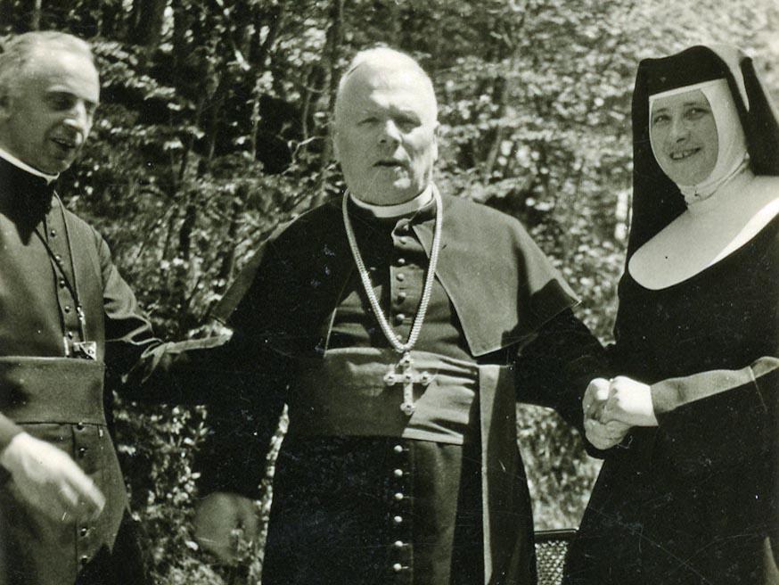 Der Bekennerbischof im Exil (1941-45): Der erkrankte Rottenburger Bischof Joannes Baptista Sproll (Mitte) im bayerisch-schwäbischen Krumbad wird von Sr. Manfreda und dem Hausgeistlichen Pater Kraus beim Stehen gestützt. (© Diözesanarchiv Rottenburg, N 72, Nr. 160-086)