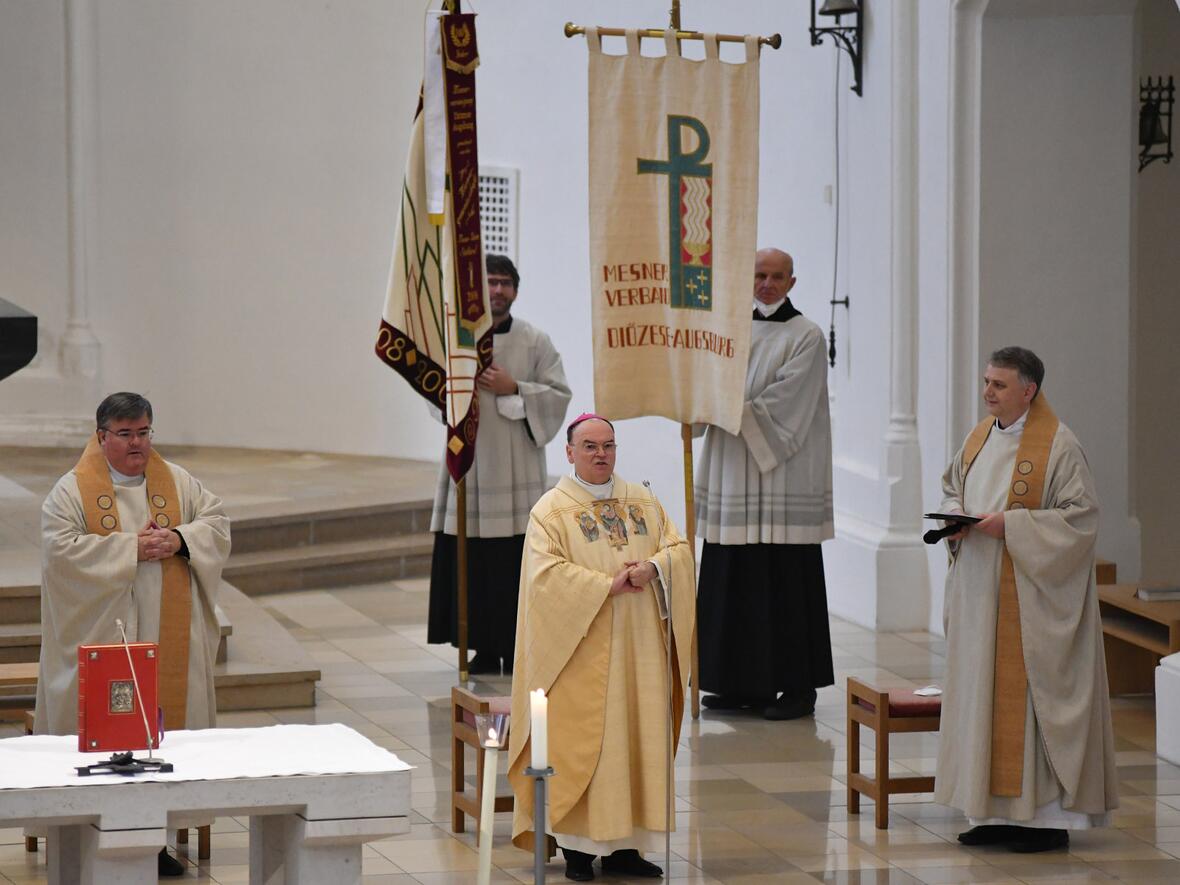 (v.l.) Diözesanpräses Domkapitular Harald Heinrich, Bischof Bertram und Stadtpfarrer Andreas Straub. Im Hintergrund die Verbandsfahnen (Fotos: Antonia Mayr / pba)