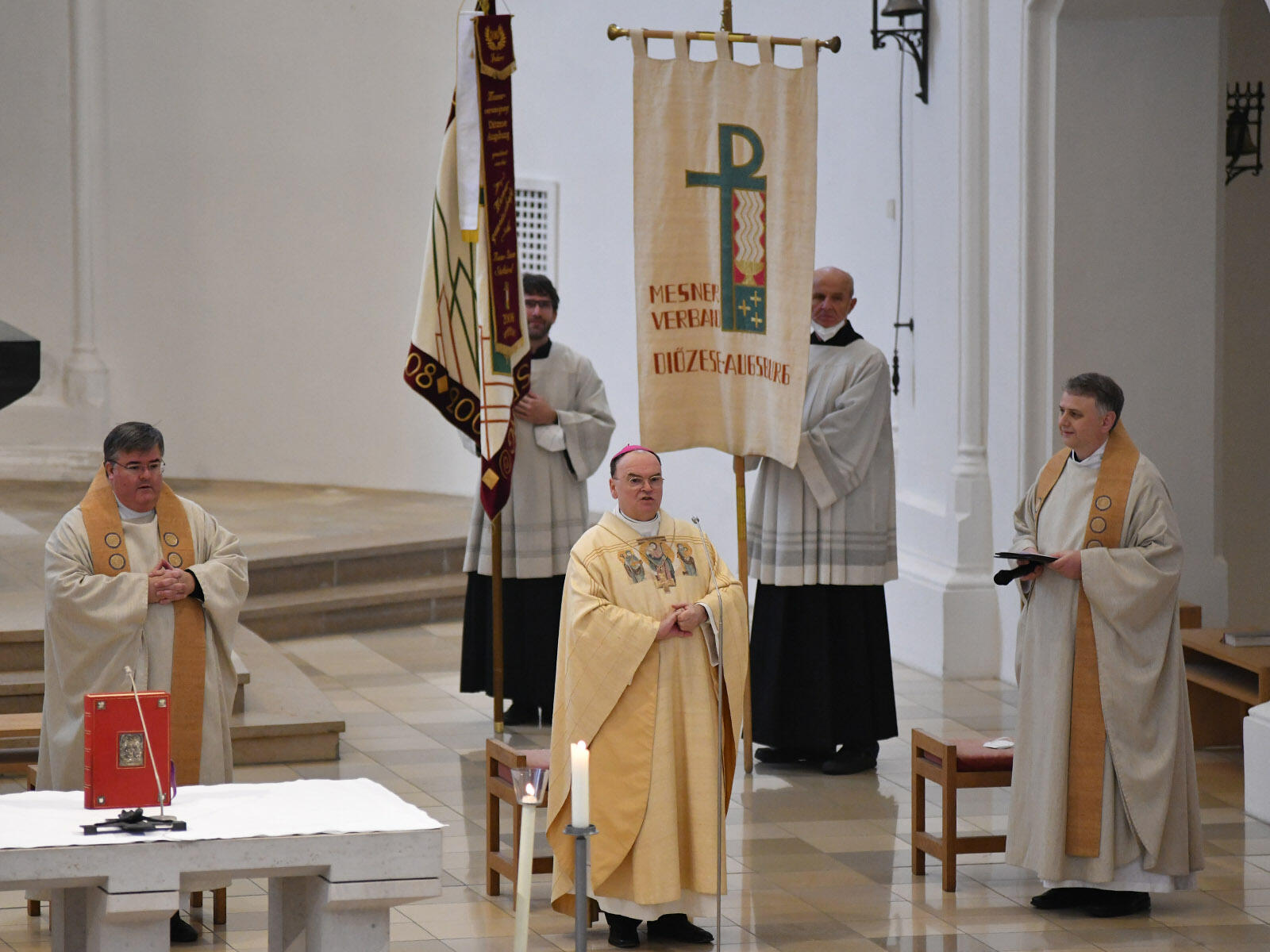 (v.l.) Diözesanpräses Domkapitular Harald Heinrich, Bischof Bertram und Stadtpfarrer Andreas Straub. Im Hintergrund die Verbandsfahnen (Fotos: Antonia Mayr / pba)