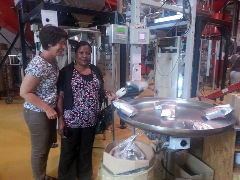 Jema Mapunda und die Diözesanreferentin der KAB, Sylvia Nerf-Kreitschy besichtigten auch die Verpackungsmaschine der Rösterei Braun.