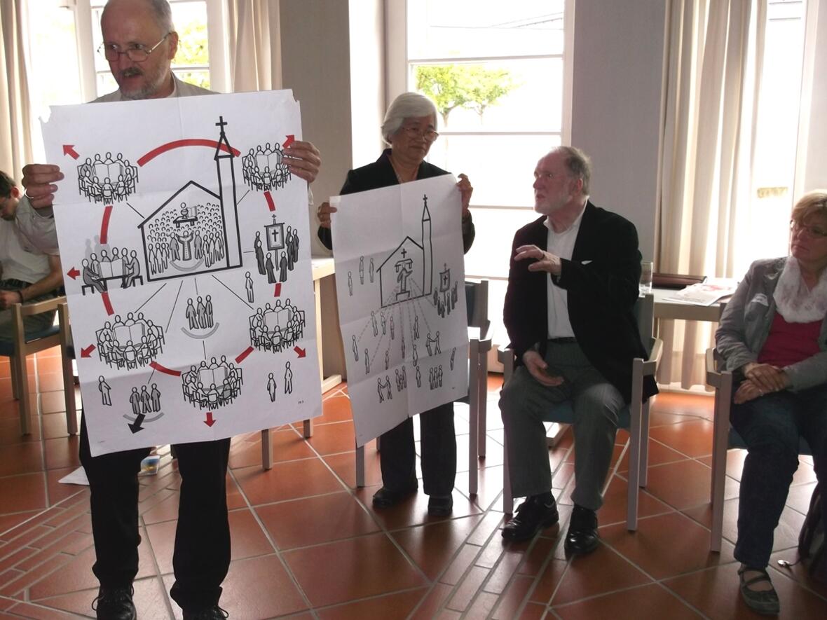 Bischof Wüstenberg und Cora Mateo mit Bildern des Pastoralmodells der SCC