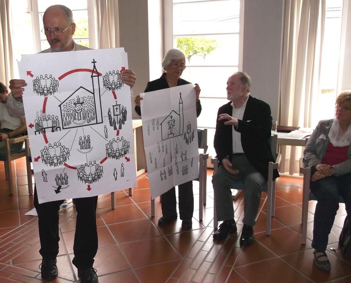 Bischof Wüstenberg und Cora Mateo mit Bildern des Pastoralmodells der SCC