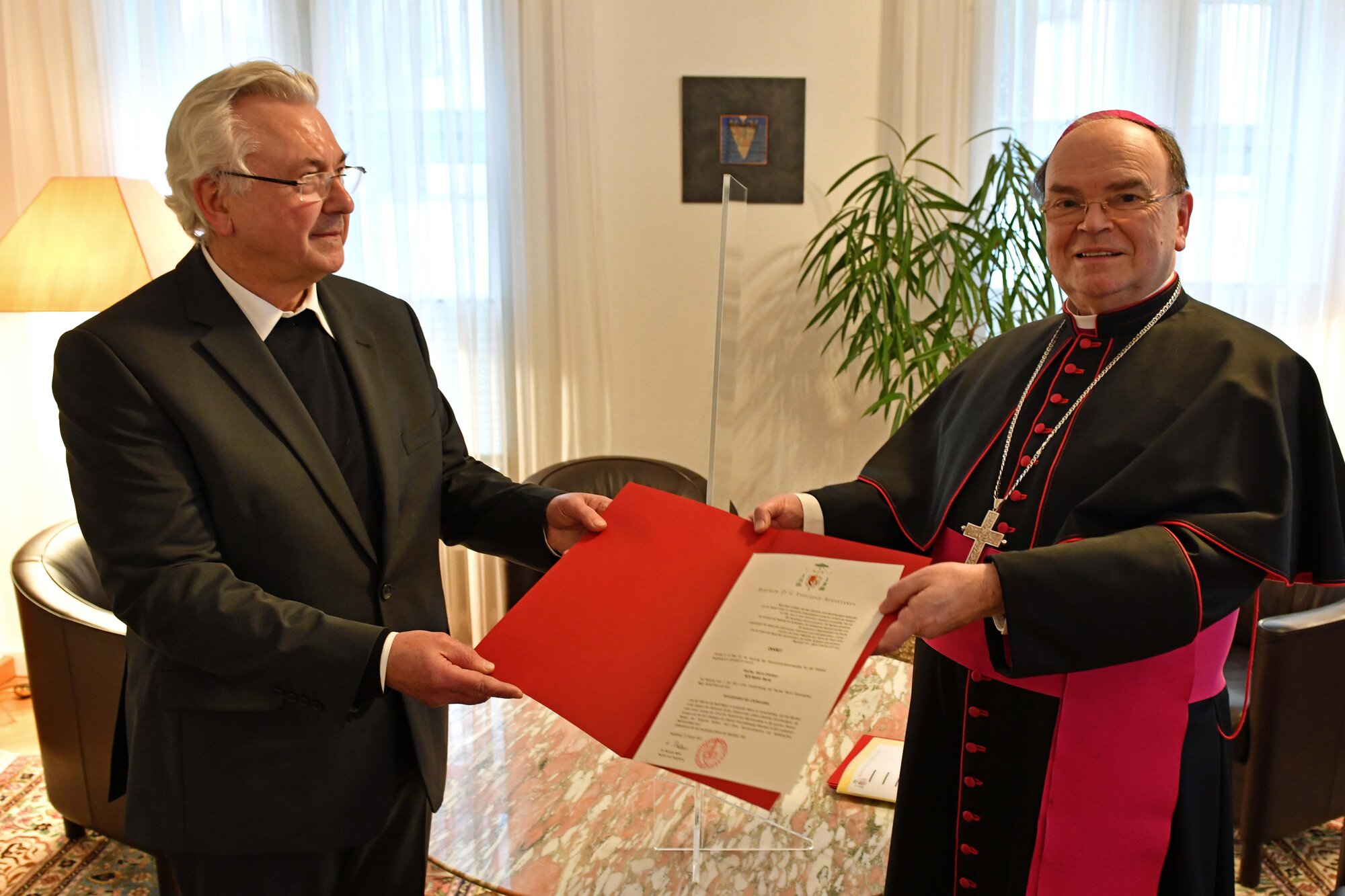 Bischof Bertram überreicht Direktor Walter Merkt das Ernennungsdekret.