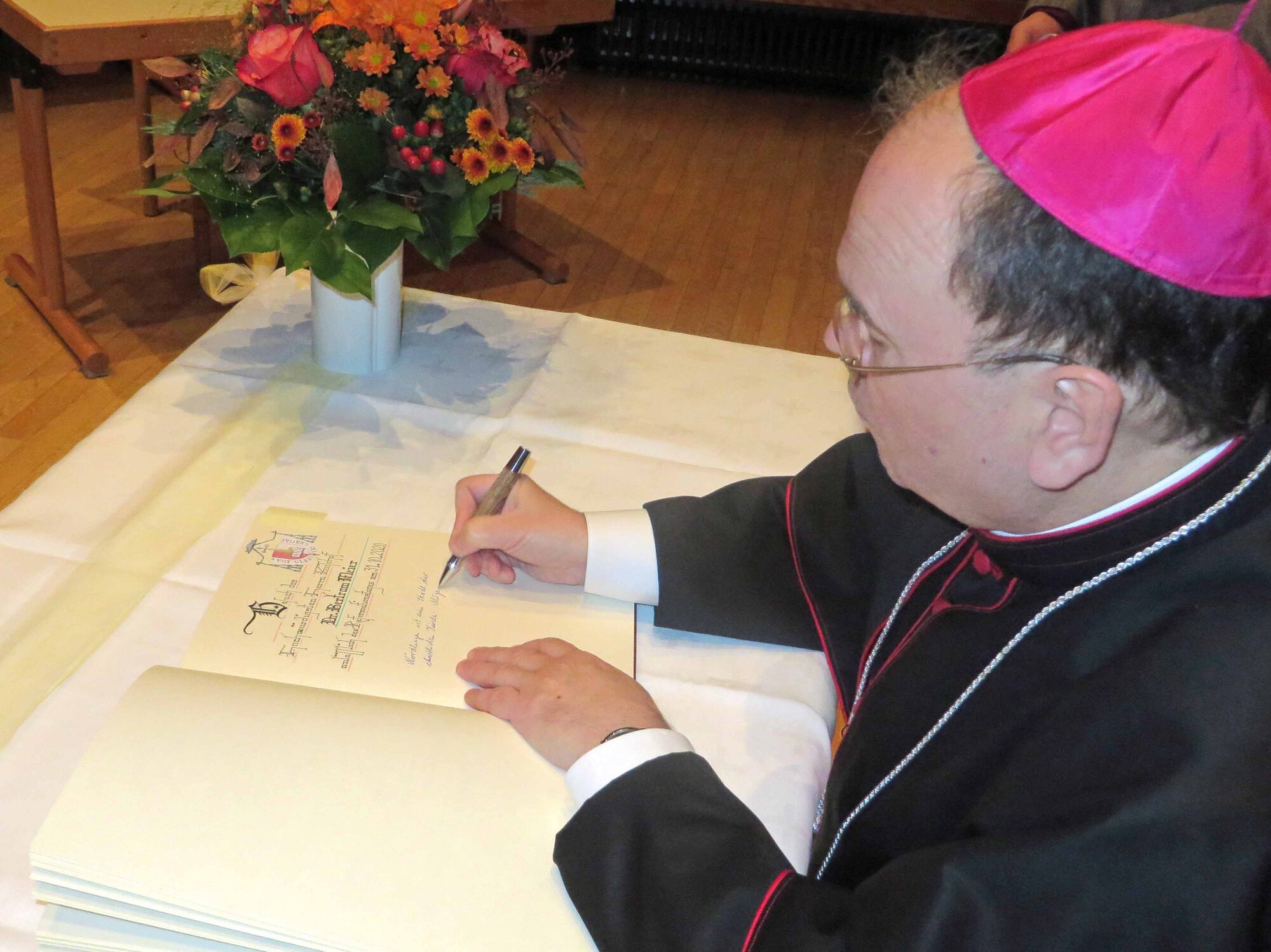 Bischof Bertram Meier trägt sich ins Goldene Buch der Stadt Nördlingen ein