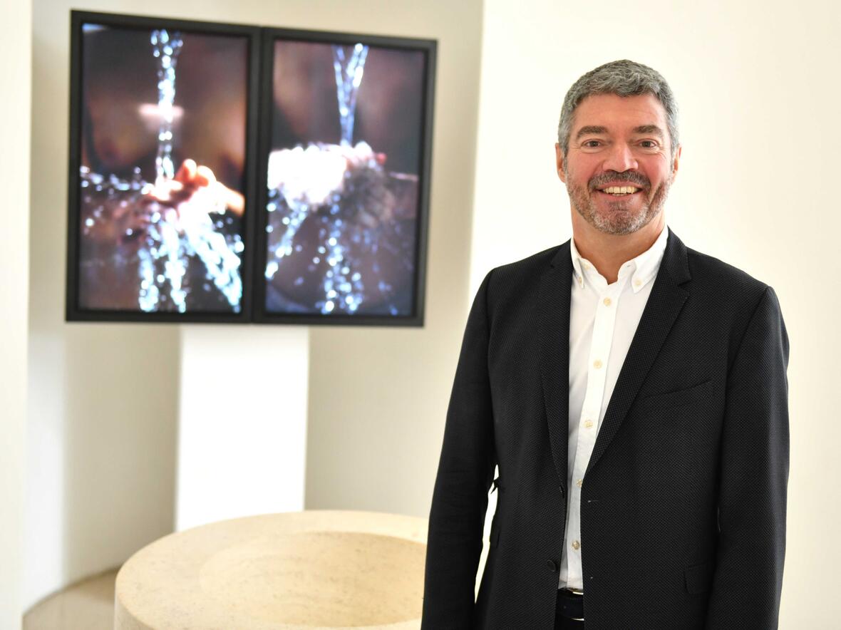 Dekan Helmut Haug in der Taufkapelle der Moritzkirche, im Hintergrund eine von vier bis September ausgestellten Videoinstallationen des Künstlers Bill Viola. (Foto: Nicolas Schnall / pba)