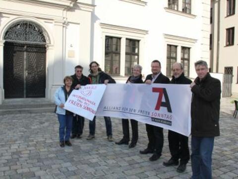 V.l. Neyla Sevinchan (Afa Augsburg), Eugen Hänel (kda Augsburg), Bernhard Stappel (Kath. Betriebsseelsorge Augsburg), Peter Ziegler (KAB Augsburg), Stefan Blumtritt (Evang. Dekanat Augsburg), Erwin Helmer und Lothar Roser (beide KAB Augsburg) bei der Plakatenthüllung im Augsburger Annahof.