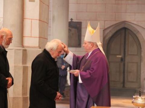 Bischof Zdarsa teilt das Aschekreuz an die Gemeinde aus.