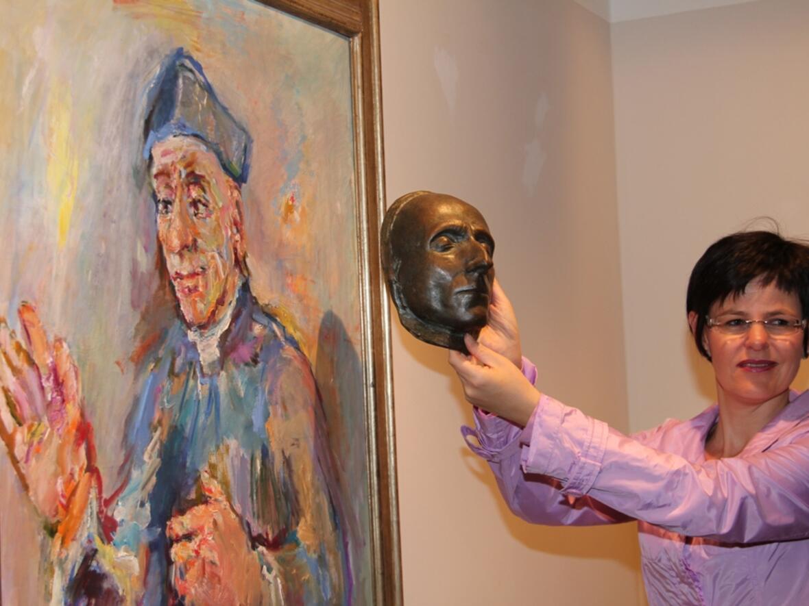Melanie Thierbach, die Leiterin des Diözesanmuseums, zeigt die Totenmaske von Vinzenz Pallotti, die der Münchner Künstler Max Faller etwa 100 Jahre nach dessen Tod angefertigt hatte und Oskar Kokoschka als Vorlage für das Gemälde diente.