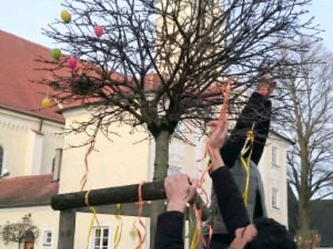 Gemeinschaftsstiftende Aktion vor der Pfarrkirche Mariä Himmelfahrt: Ali und Mohamad, beide Flüchtlinge aus Syrien, helfen in Türkheim beim traditionellen Schmücken der Osterbäume. (Foto: Helferkreis Türkheim/Rummel)