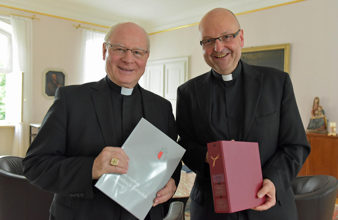 Pater Stefan Kling (rechts) überreicht Bischof Konrad die beiden Neuerscheinungen. (Fotos: pba/Romana Kröling)