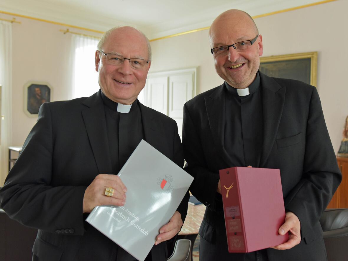 Pater Stefan Kling (rechts) überreicht Bischof Konrad die beiden Neuerscheinungen. (Fotos: pba/Romana Kröling)