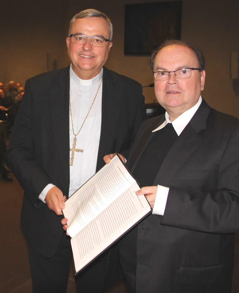 Bischof Karl-Heinz Wiesemann (links) übergibt symbolisch zur Weiterarbeit dem Vorsitzenden der ACK Bayern, Prälat Bertram Meier, das Wort der ACK zu 500 Jahre Reformation. (Foto: ACK/Witzenbacher)