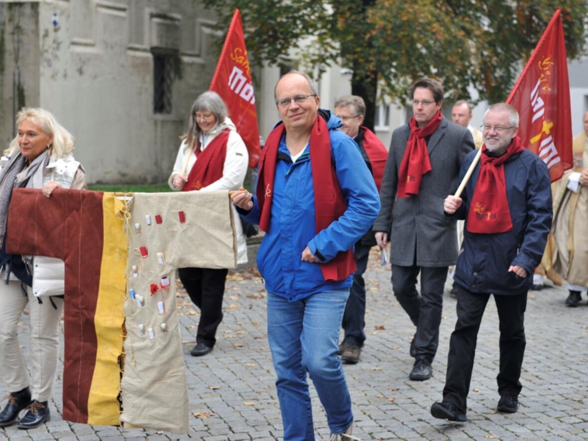 Mitglieder der Martinusgemeinschaft tragen den Martinusmantel durch Kaufbeuren, angefertigt von der Lörracher Künstlerin Astrid Eichin. (Fotos: Gerhard Drescher)