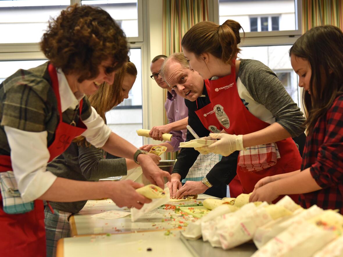 Weihbischof Florian Wörner bereitete heute mit Schülerinnen und Schülern sowie mit der Schulleitung der Augsburger Maria-Stern-Schulen Wraps zu. (Fotos: Romana Kröling / pba)