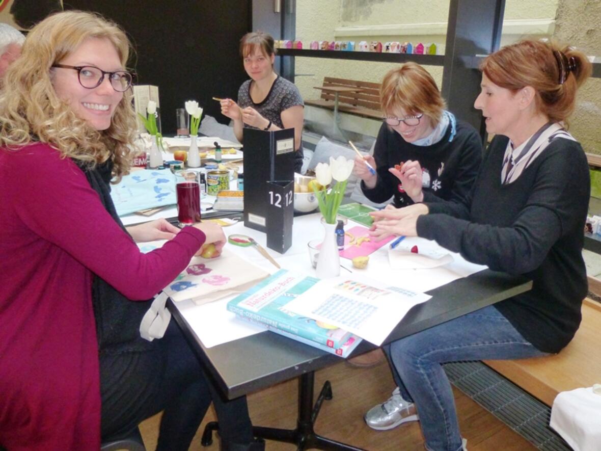 Die Designerin Eva Neumann (recht) und Tanja Blum (links) haben zu „Kunst & Kuchen“ ins Café Samocca geladen. (Foto: Caritas Augsburg/Gerlinde Knoller)