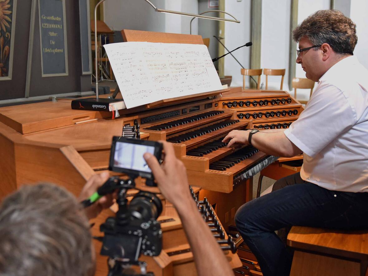 Kirchenmusiker Peter Bader an der Orgel der Ulrichsbasilika zu Dreharbeiten für die BR-Sendung "Stofferl Well's Bayern", die im Oktober ausgestrahlt wird. (Foto: Nicolas Schnall / pba).