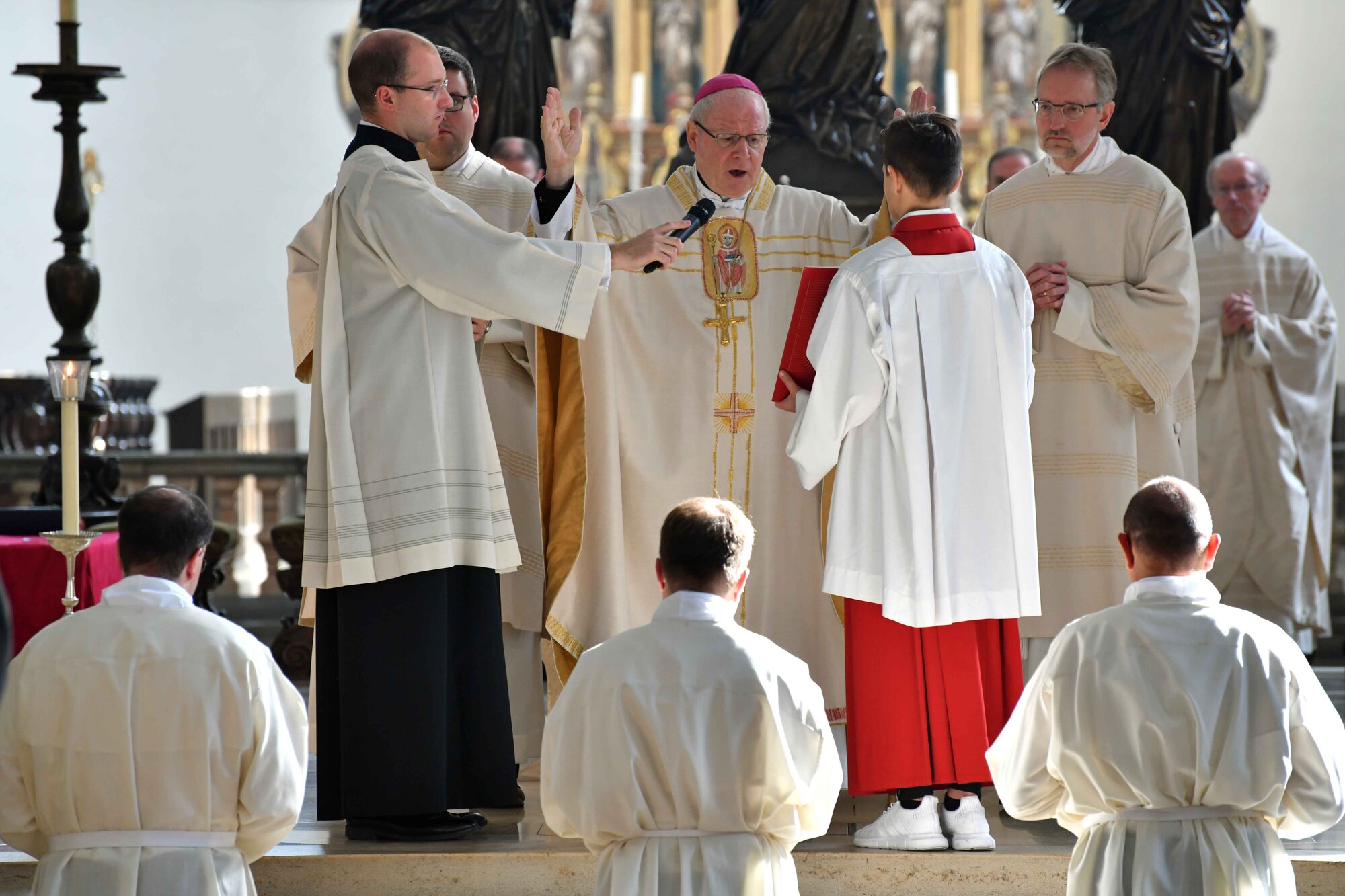 Bischof Konrad während des Weihegebets, die drei neuen Diakone knien vor dem Altar.