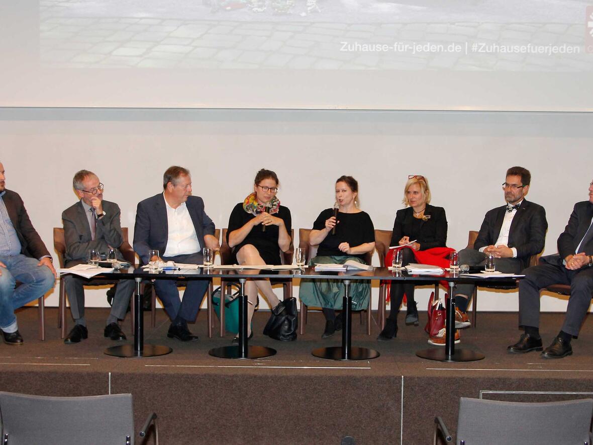 Von links: Jörn Scheuermann, Prälat Dr. Peter Neher, Johann Häusler, Stephanie Schuhknecht, die Moderatorin Daniela Hungbaur, Dr. Simone Strohmayr, Thomas Weiand und Johannes Hintersberger. Foto: Caritas Augsburg/Bernhard Gattner.