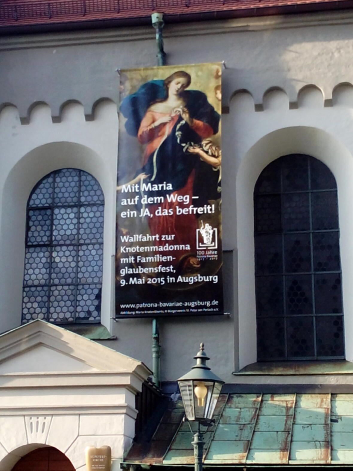 Ein großes Banner an der Außenfassade der Kirche St. Peter am Perlach kündigt den großen Wallfahrtstag an. (Foto: Bischöfliches Seelsorgeamt)