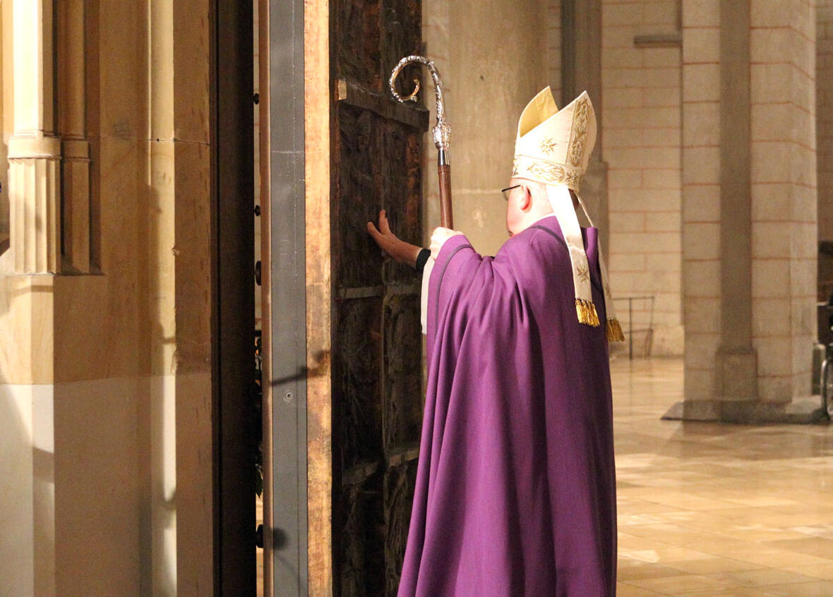 Bischof Dr. Konrad Zdarsa öffnet die Heilige Pforte und tritt hindurch. (Foto: Annette Zoepf / pba)
