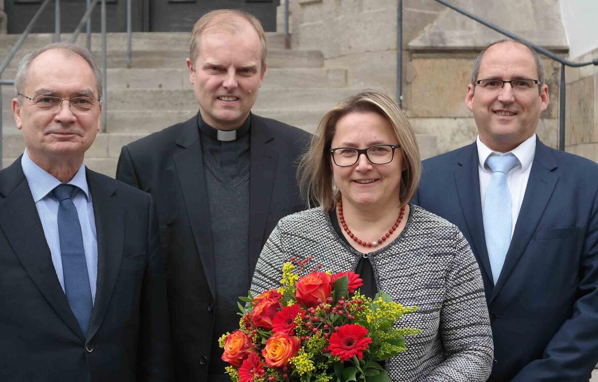 Blumen für Preisträgerin Christine Frank. Mit ihr freuen sich (von links) Ulrich Haaf, Direktor des Schulwerks der Diözese Augsburg, Weihbischof Florian Wörner und Peter Kosak. Er wird ab Januar die Leitung des Schulwerks übernehmen. (Foto: Karl-Georg Michel/pba)
