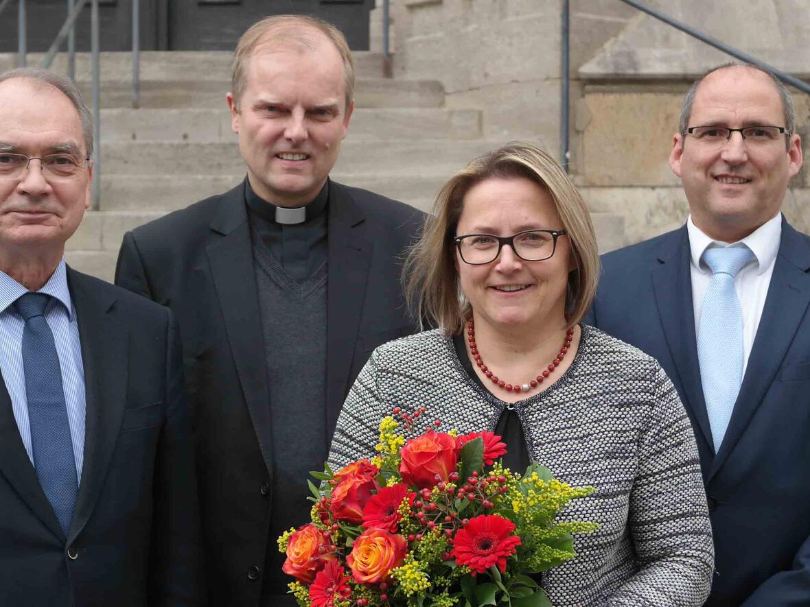 Blumen für Preisträgerin Christine Frank. Mit ihr freuen sich (von links) Ulrich Haaf, Direktor des Schulwerks der Diözese Augsburg, Weihbischof Florian Wörner und Peter Kosak. Er wird ab Januar die Leitung des Schulwerks übernehmen. (Foto: Karl-Georg Michel/pba)