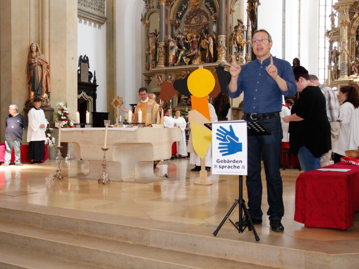 Michael Geisberger von der Hörgeschädigtenseelsorge der Diözese Augsburg übersetzte jedes Wort im Gottesdienst simultan in die Gebärdensprache. (Foto: Caritas/Bernhard Gattner)