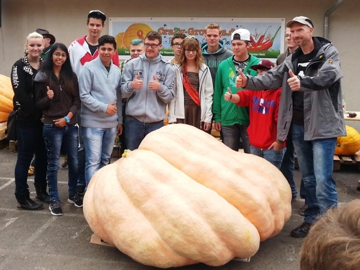 So sehen Sieger aus: Andreas Hofmann (rechts) und sein Team haben beim Kürbiswiegen im thüringischen Fambach den schwersten Kürbis beigesteuert. (Foto: Gemeinde Fambach)