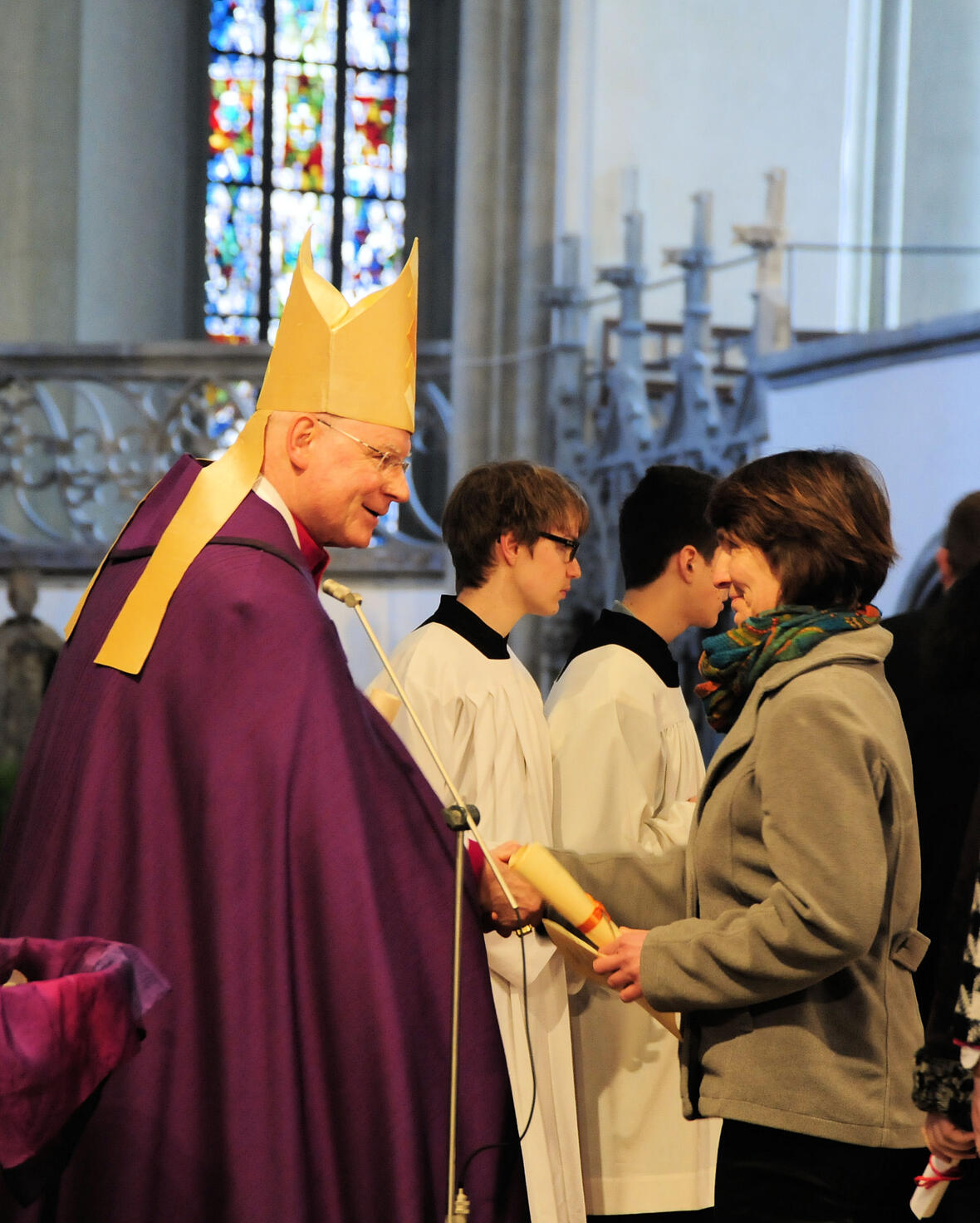 Eine Taufbewerberin überreicht Bischof Konrad das Empfehlungsschreiben für die Zulassung zu den Sakramenten.