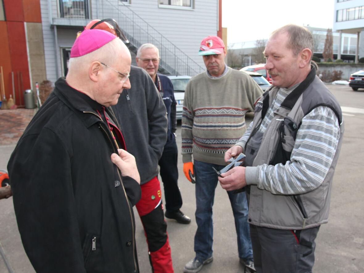 Michael Thannhäuser (re.), Hausmeister im Abbé-Pierre-Zentrum, überreichte Bischof Dr. Konrad Zdarsa ein selbst geschmiedetes Eisenkreuz. Foto: Caritas.
