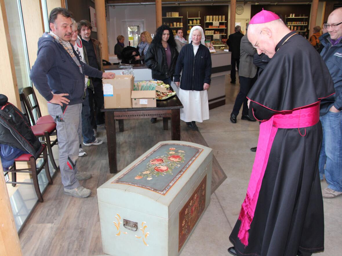 Da staunte Augsburgs Bischof Dr. Konrad Zdarsa: Klienten hatten die Holzkiste neu bemalt. Sie war keine Antiquität, wie der Bischof zuvor vermutet hatte. Foto: Caritas.