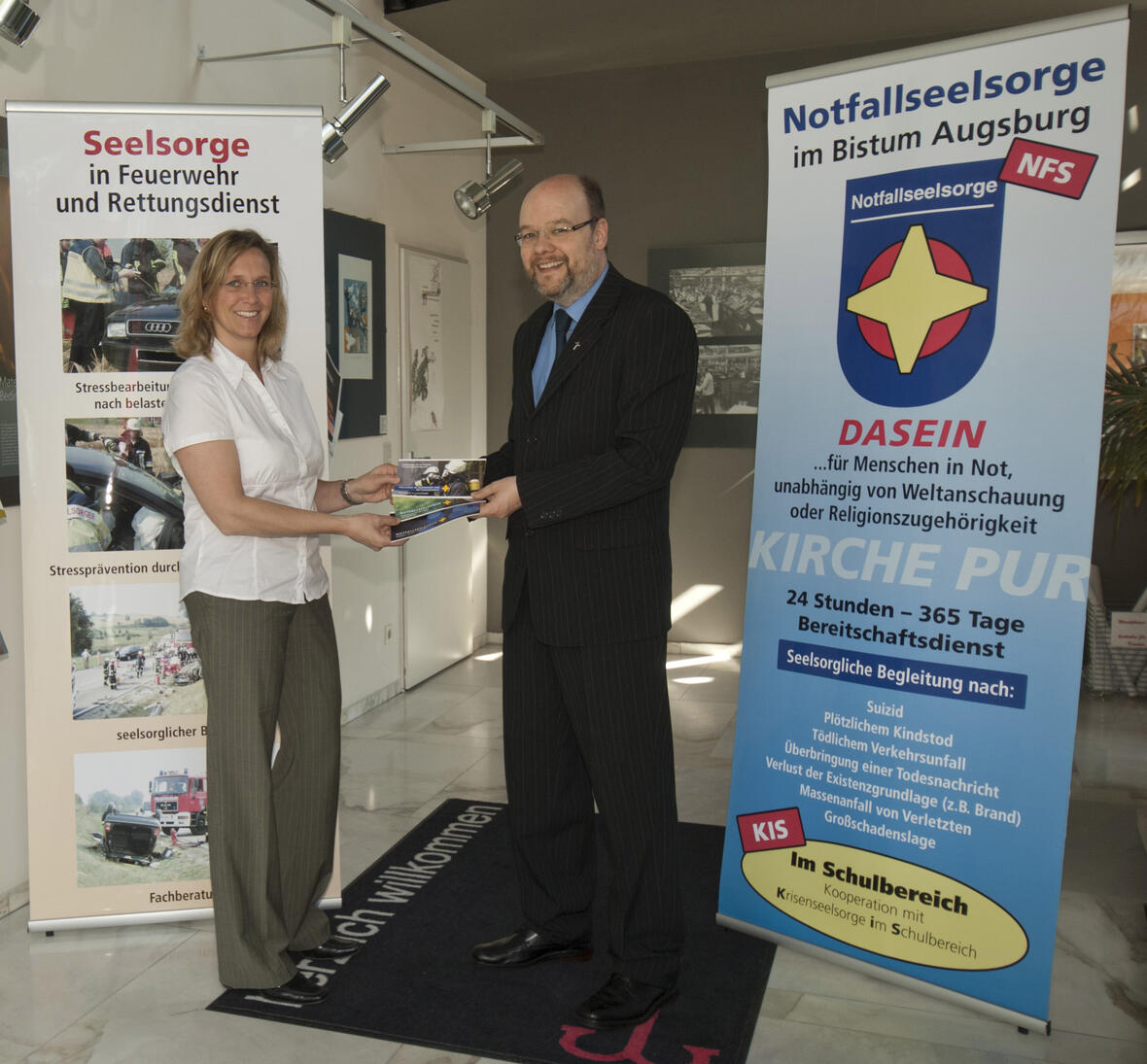 Der Leiter der Notfallseelsorge, Diakon Dr. Edgar Krumpen, und  Geschäftsführerin Johanna Mayr-Walch bei der Übergabe der Aufsteller. Foto: Uwe Spielhaupter