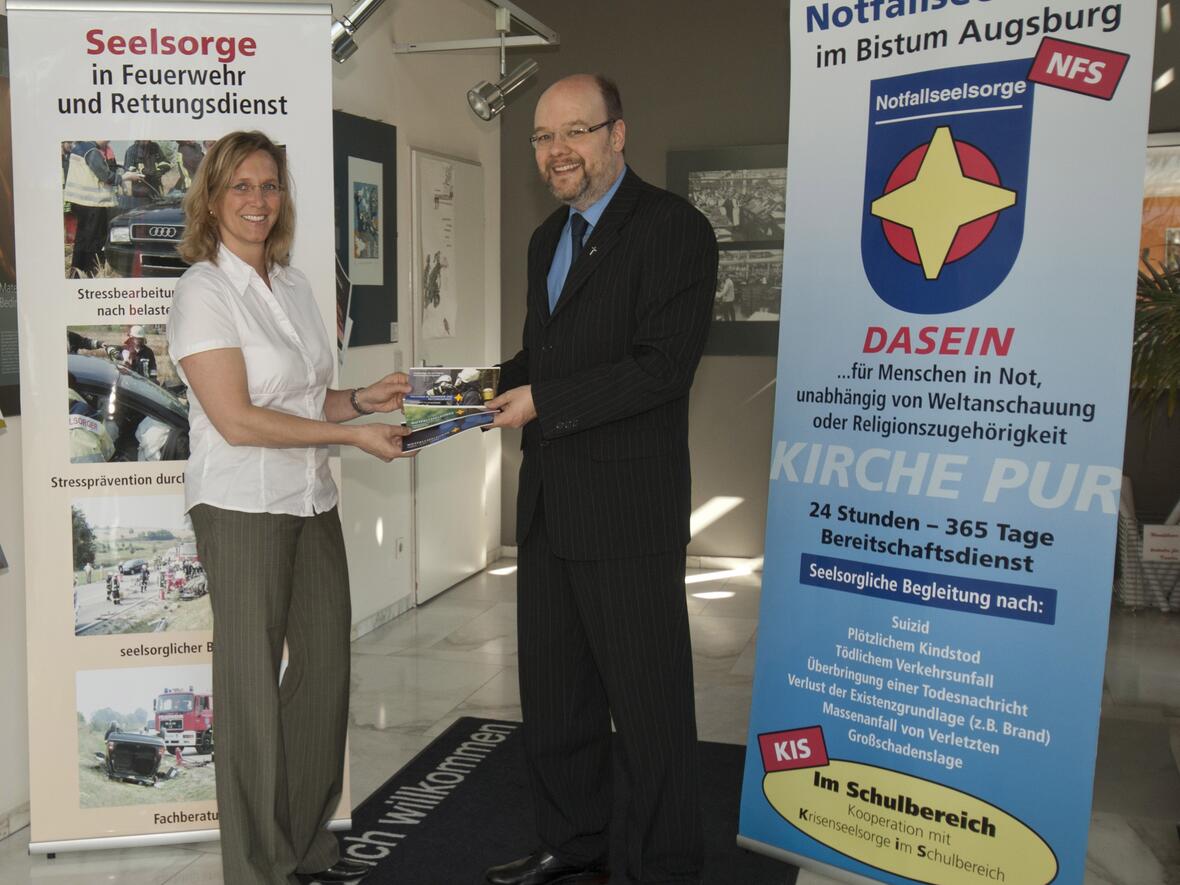 Der Leiter der Notfallseelsorge, Diakon Dr. Edgar Krumpen, und  Geschäftsführerin Johanna Mayr-Walch bei der Übergabe der Aufsteller. Foto: Uwe Spielhaupter