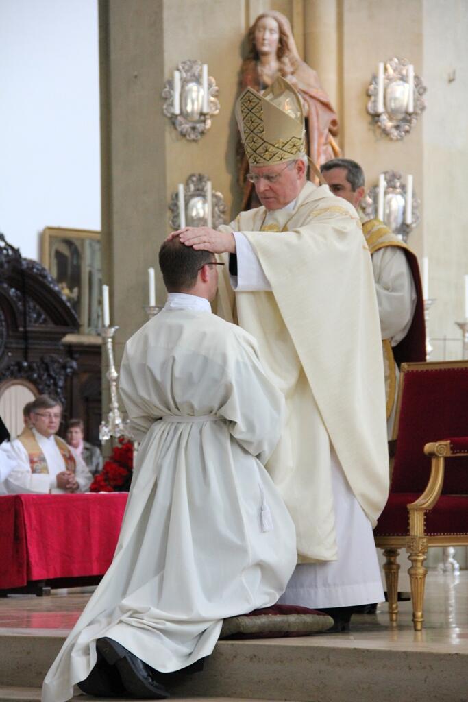 Dem Kandidaten legt der Bischof zur Weihe die Hand auf. 