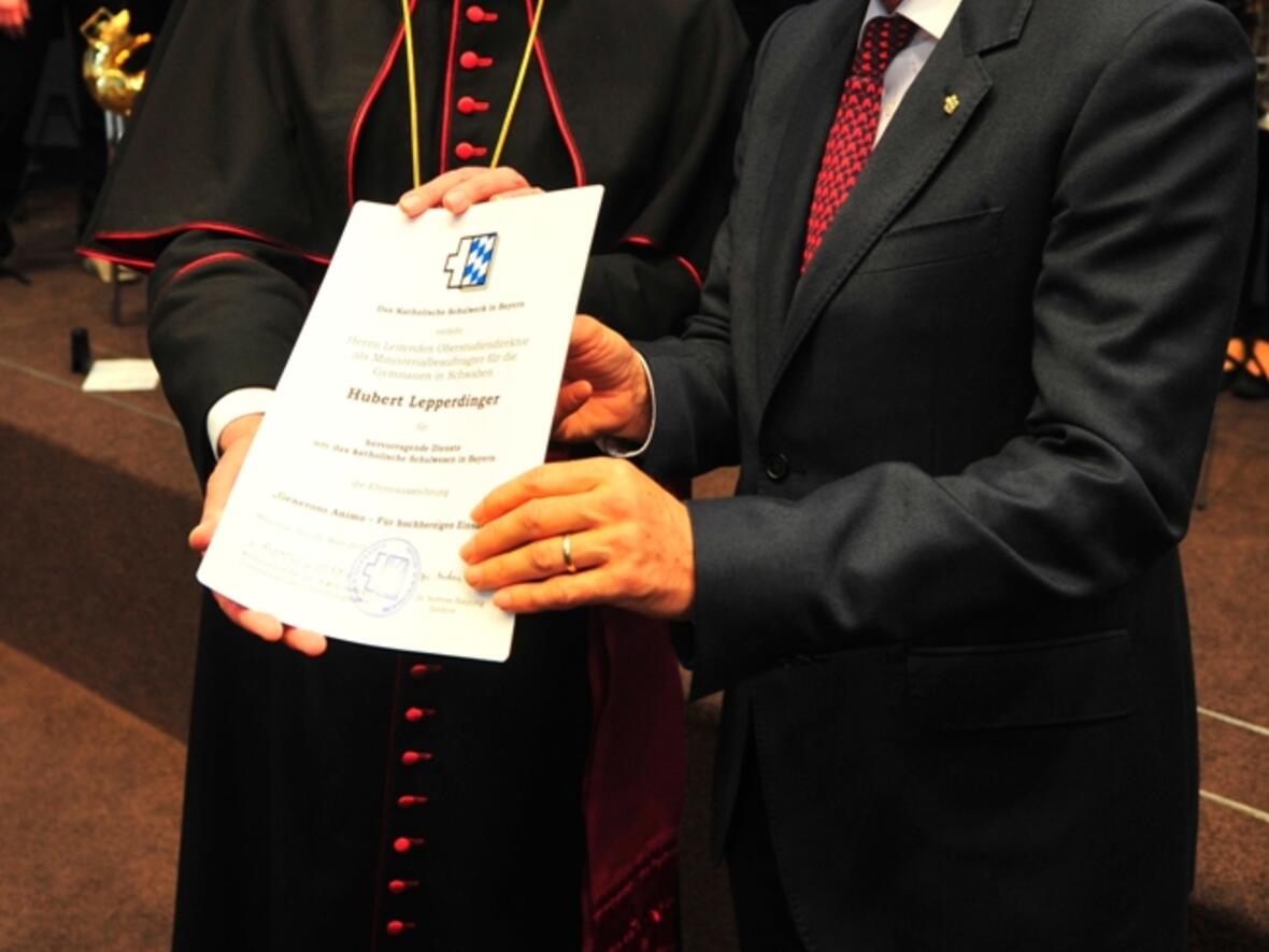 Weihbischof Anton Losinger übergibt die Ehrenurkunde an Hubert Lepperdinger.