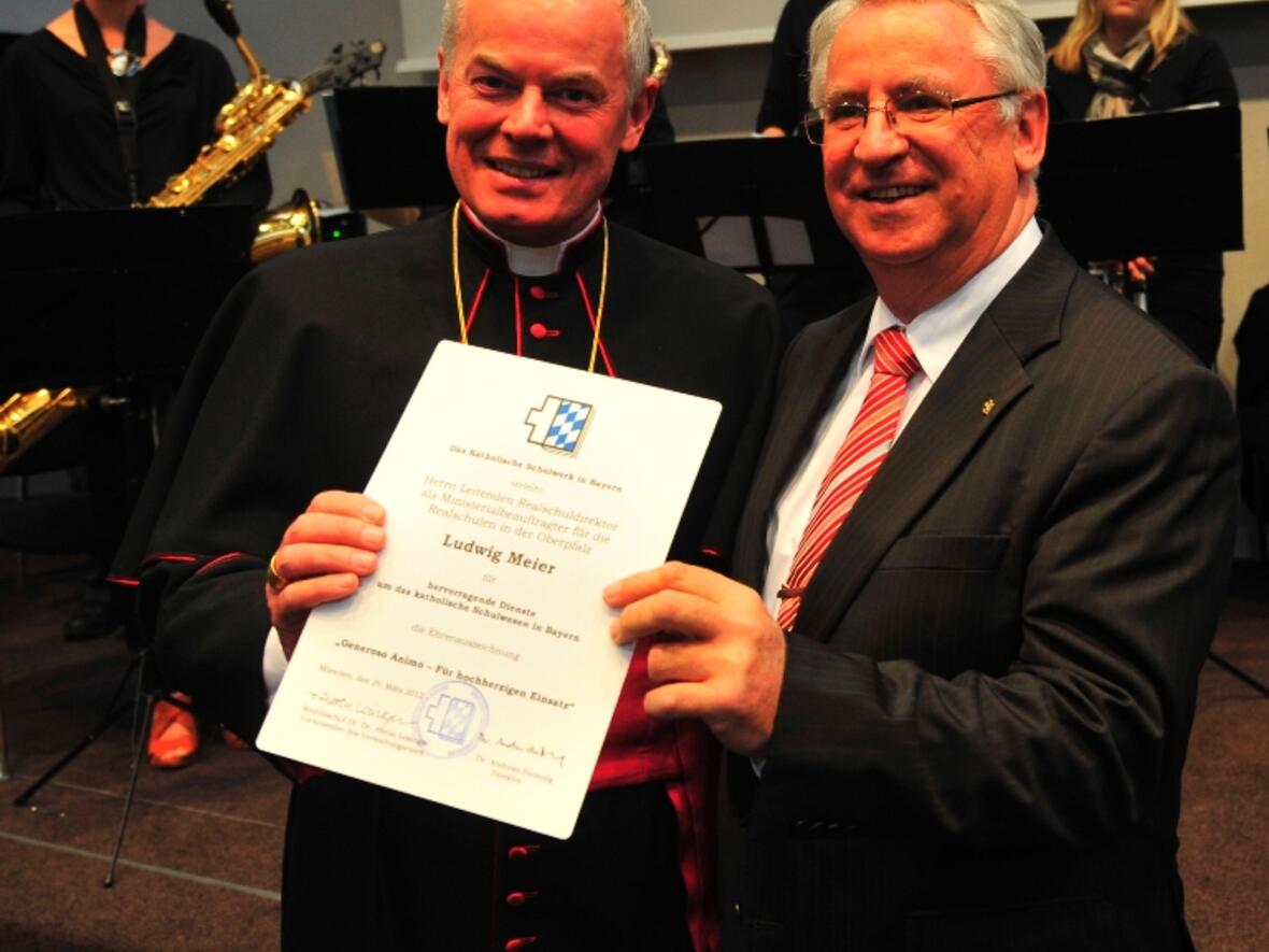 Weihbischof Anton Losinger übergibt die Ehrenurkunde an Ludwig Meier.