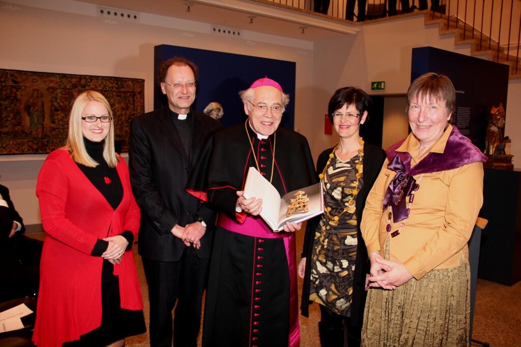 Weihbischof em. Josef Grünwald mit der neuen Festschrift, überreicht von Domkapitular Wolfgang Hacker (2.l.) und Melanie Thierbach (2.v.r.).
