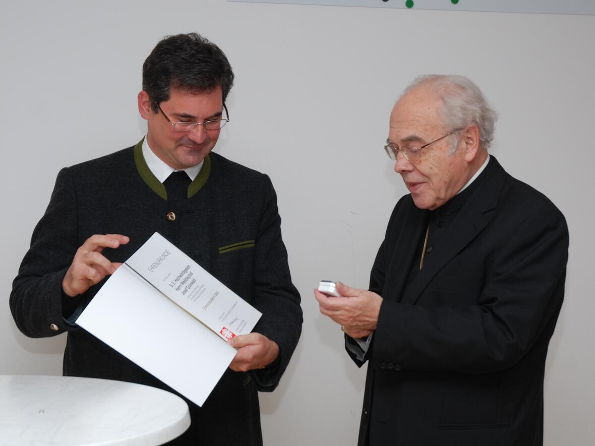 Diözesan-Caritasdirektor Pfarrer Dr. Andreas Magg (li.) überreichte Weihbischof Josef Grünwald (re.) die Ehrennadel der Caritas in Gold. Foto: Caritas.