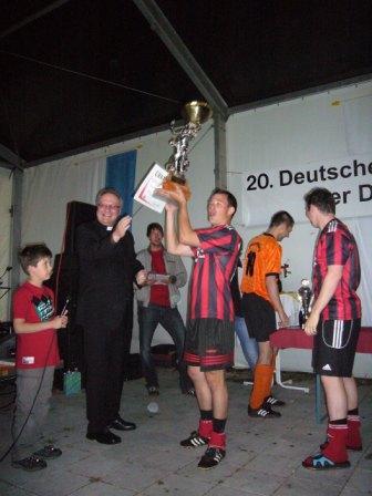 Generalvikar Karlheinz Knebel übergibt den Pokal an die Gewinner.