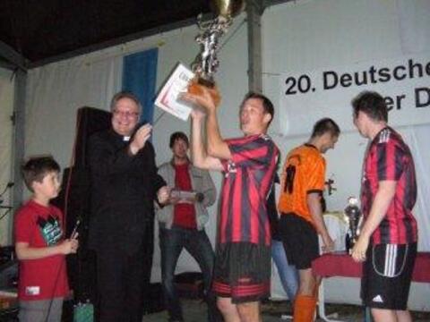 Generalvikar Karlheinz Knebel übergibt den Pokal an die Gewinner.