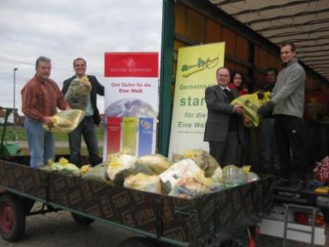 Prälat Dr. Bertram Meier (3.v.l.) und Gregor Uhl (2.v.l.) halfen beim Verladen der Sammeltüten zum Abschluss der diesjährigen Straßensammlungen kräftig mit.