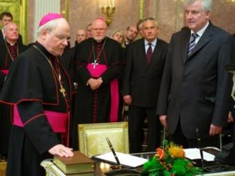 Bischof Dr. Konrad Zdarsa (links vorne) sprach mit der rechten Hand auf der Bibel die Eidesformel. 2. R. v.l. Weihbischof Dr. Dr. Anton Losinger (Augsburg), Erzbischof Reinhard Marx (München), Staatsminister für Unterricht und Kultus Ludwig Spaenle und Ministerpräsident Horst Seehofer. Bild: Fuchs