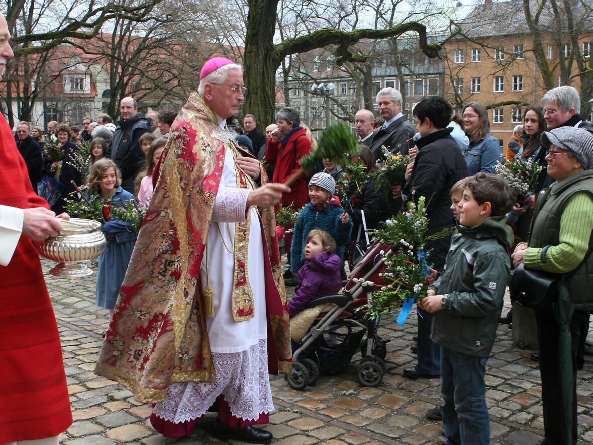 Bischof Dr. Walter Mixa segnet die Palmzweige der Gläubigen vor dem Augsburger Mariendom.