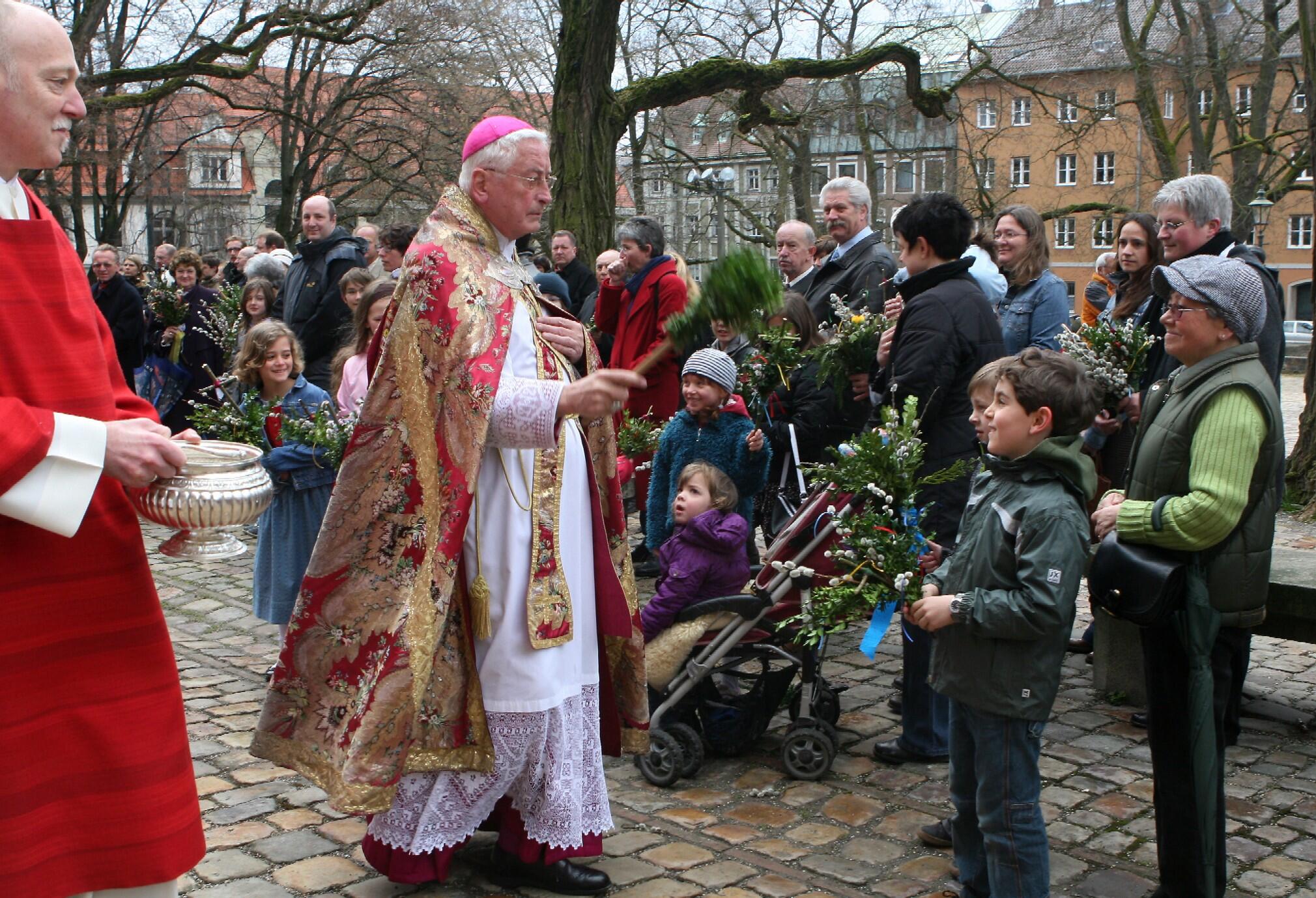 Bischof Dr. Walter Mixa segnet die Palmzweige der Gläubigen vor dem Augsburger Mariendom.