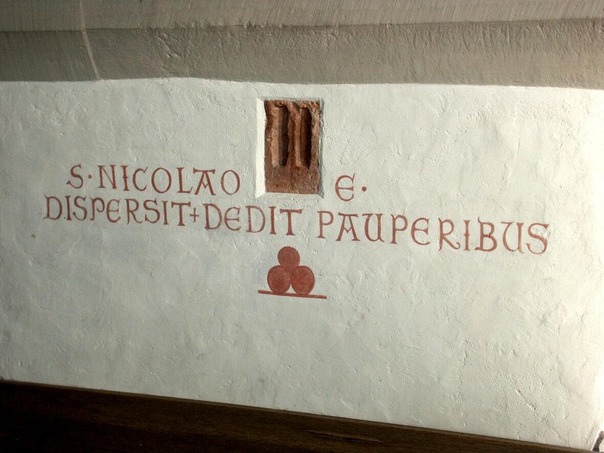 Die lateinische Inschrift auf dem Nikolaus-Altar lautet übersetzt: Dem Heiligen Bischof Nikolaus. Er hat an die Armen verteilt und ihnen gegeben.