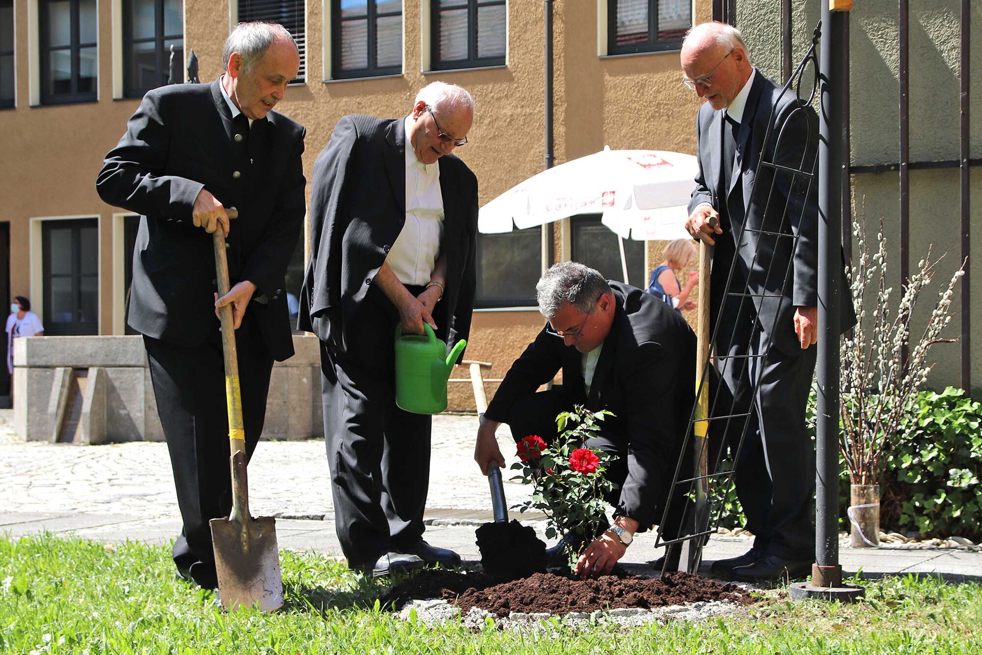 Nach dem Gottesdienst mit Bischof Bertram pflanzten vier Caritas-Direktoren einen Rosenstrauch zur Erinnerung an das Jubiläum im Innenhof des Augsburger Caritas-Hauses. (V. l.) Landes-Caritasdirektor Prälat Bernhard Piendl, sein Vorgänger und ehemaliger Diözesan-Caritasdirektor Prälat Karlheinz Zerrle, Diözesan-Caritasdirektor Domkapitular Dr. Andreas Magg und dessen Vorgänger Prälat Peter C. Manz. (Foto: Caritas Augsburg / Bernhard Gattner)