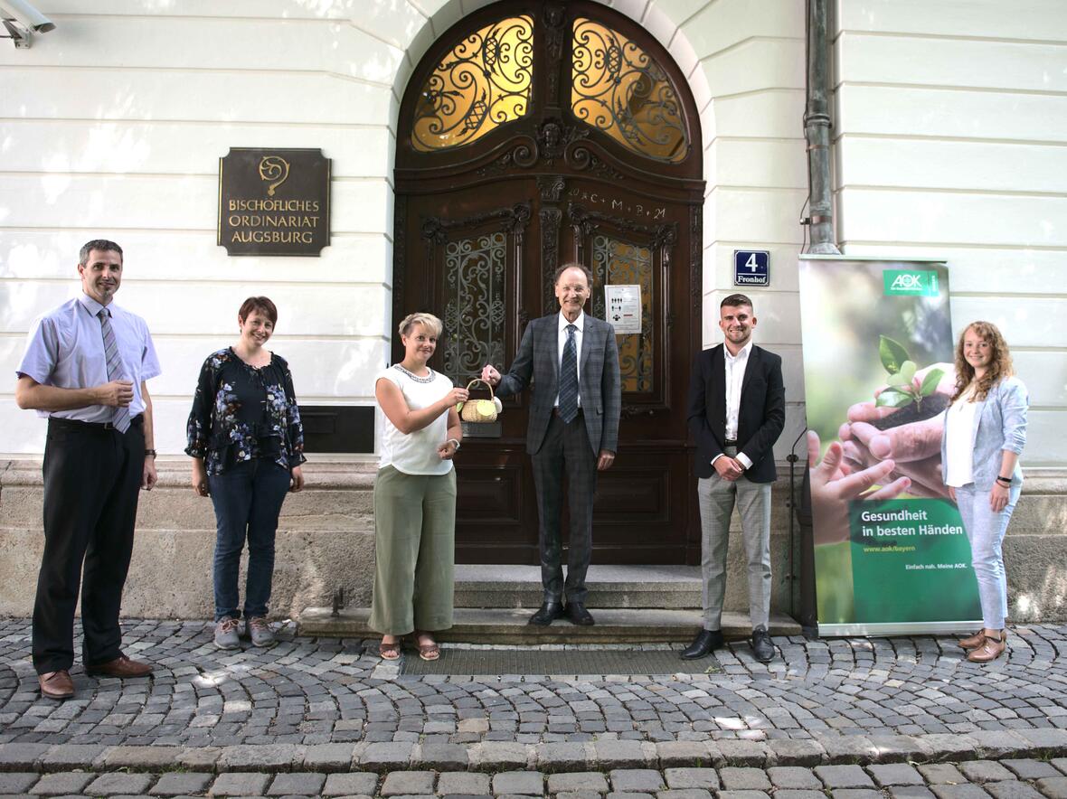 Generalvikar Dr. Wolfgang Hacker hat per Losziehung die Gewinner des Gesundheitstags ermittelt. Neben dem Projektteam waren auch Mitarbeiter der AOK Bayern dabei (Maria Steber / pba).