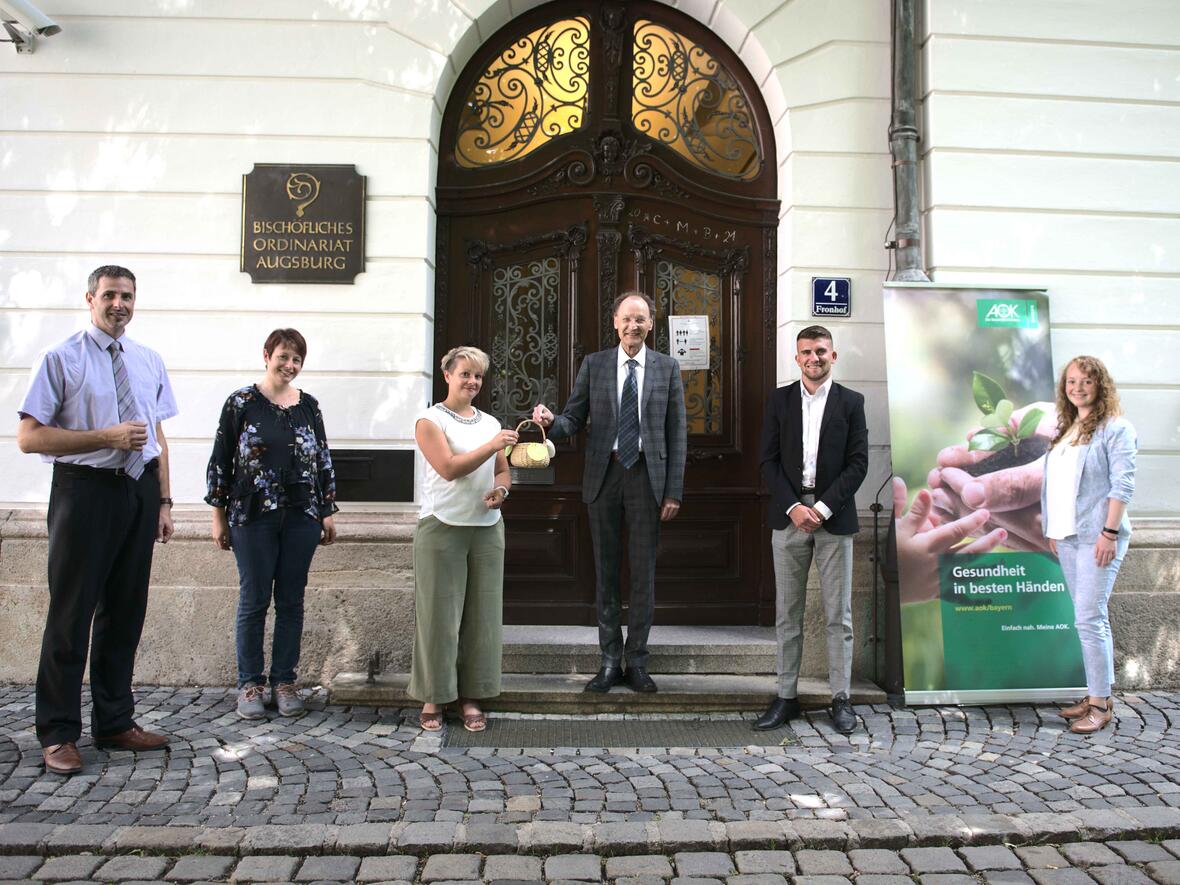 Generalvikar Dr. Wolfgang Hacker hat per Losziehung die Gewinner des Gesundheitstags ermittelt. Neben dem Projektteam waren auch Mitarbeiter der AOK Bayern dabei (Maria Steber / pba).