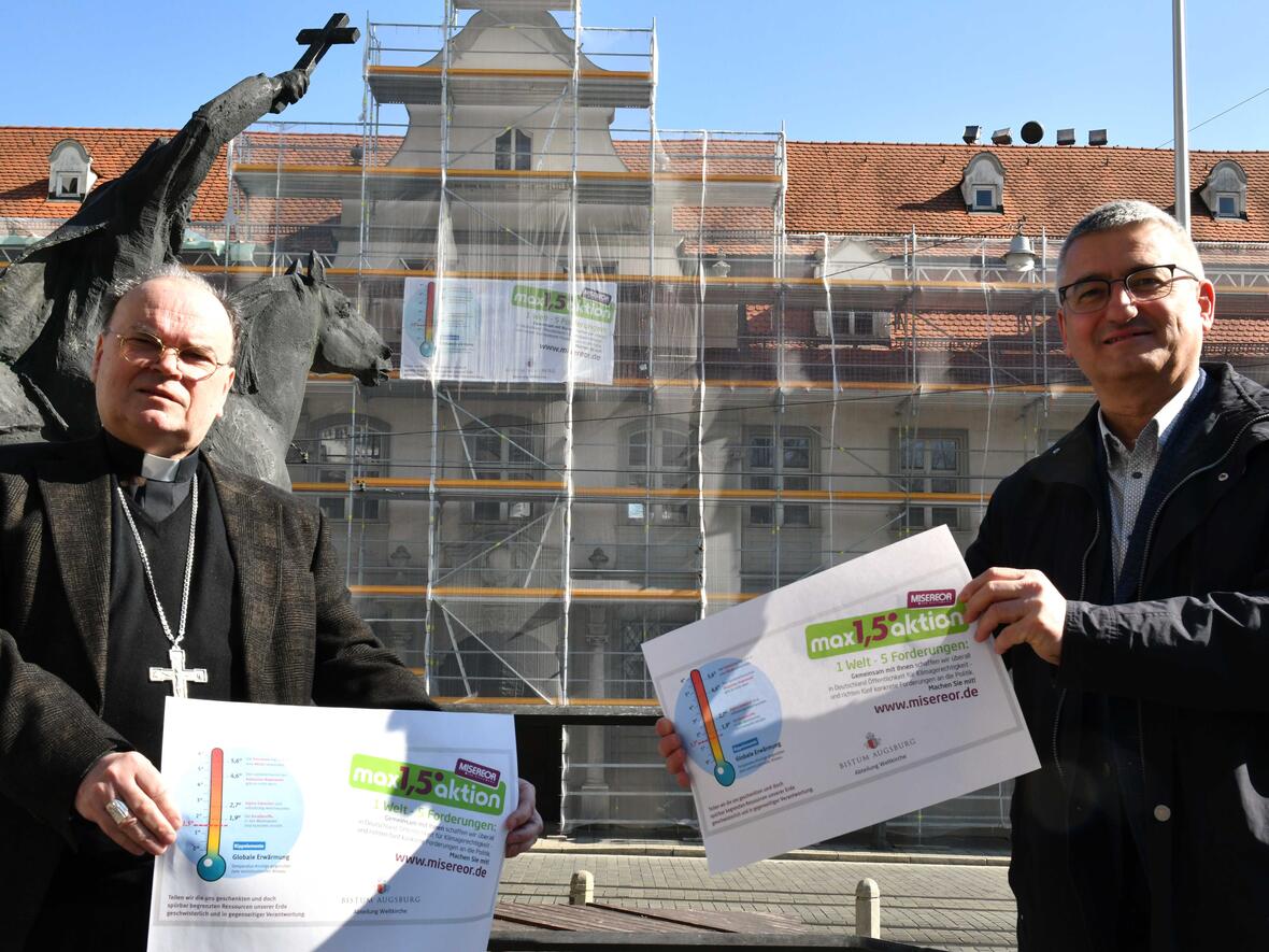 Bischof Dr. Bertram Meier und Anton Stegmair, Leiter der Abt. Weltkirche im Bistum, präsentieren das Logo für die MISEREOR-Fastenaktion. Im Hintergrund prangt das Banner am Bischofshaus, das die ganze Fastenzeit über dort hängen wird (Foto: Ulrich Bobinger / pba).